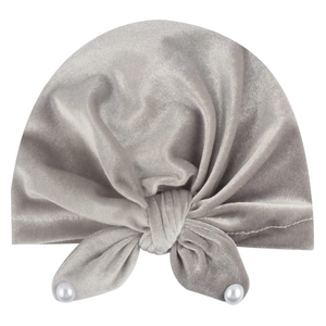 Detail of grey velvet baby turban hat featuring a large bow and white faux pearls