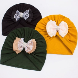 Infant turban hats in black, dark green, and yellow with lace pearl bow details