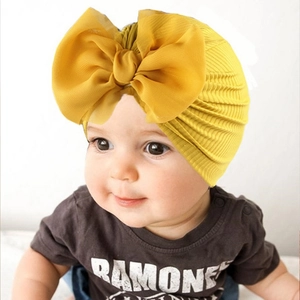 Détail du bonnet turban jaune pour bébé avec grand nœud en mousseline et texture côtelée