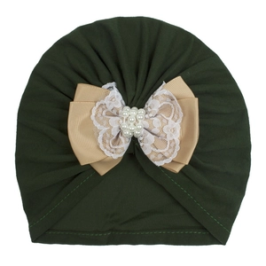 Detailed close-up of dark green baby turban with ribbon, lace, and faux pearl bow