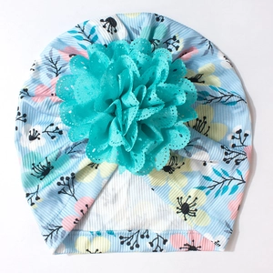 Détail du bonnet turban bébé en tissu côtelé bleu clair avec grande fleur en dentelle