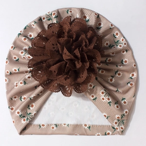 Vue détaillée du turban pour bébé en tricot kaki avec motif marguerite et fleur en dentelle
