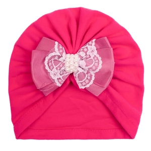 Detail of rose red baby turban hat with lace bow and pearl embellishments