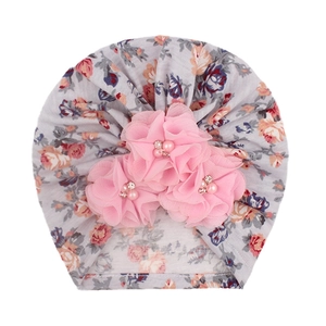Détail du turban pour bébé à fleurs avec fleurs en mousseline rose et perles nacrées