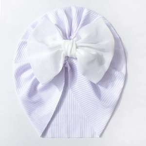 Détail du bonnet côtelé violet clair pour bébé avec un grand nœud en mousseline blanche