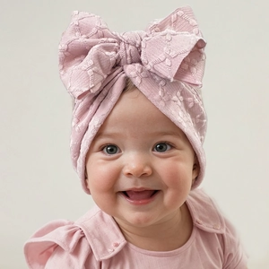 Detail of baby pink headband with large bow in high-quality textured knit fabric