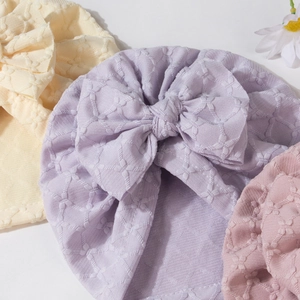 Detail shot of newborn knot turbans with large bows in soft pastel yellow and purple