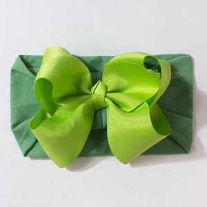 Detail of baby headband with oversized lime green ribbed bow and dark green elastic band