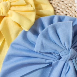 Close-up of baby turbans with large bows in ribbed elastic knit fabric and vibrant colors