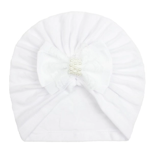 Close-up of white baby turban hat with soft knit fabric and pearl-beaded bow detail