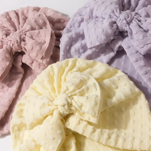 Detailed view of jacquard baby turbans with large bows in soft pastel colors