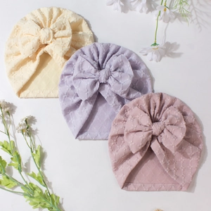 Soft striped baby turban hats with large bows in cream, lilac, and pink colors
