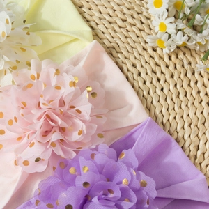 Détail de bandeaux bébé avec fleurs en organza à pois dorés sur paille