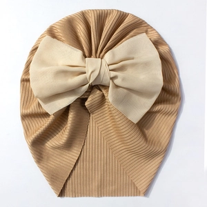 Détail du bonnet turban côtelé pour bébé couleur camel foncé avec grand nœud crème