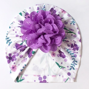 Détail du turban bébé en maille côtelée blanche avec imprimé floral et fleur en tissu