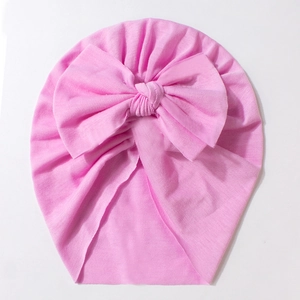 Detail shot of bright pink baby turban hat with oversized bow in soft ribbed cotton