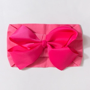 Detailed view of fuchsia grosgrain ribbon bow on a soft elastic baby headband