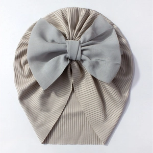 Détail du bonnet turban pour bébé en maille côtelée kaki avec un grand nœud en mousseline
