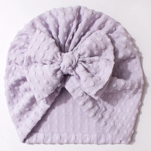Detail shot of lavender jacquard textured baby hat with large bow and soft fabric