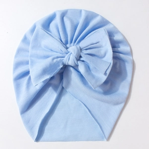 Detailed close-up of light blue baby hat with a soft knit bow and cotton texture