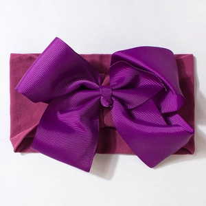 Detail of the oversized purple ribbed bow and elastic knit fabric on infant headband