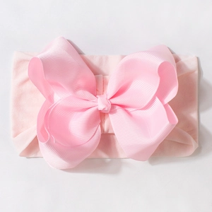 Elastic baby headband with a large light pink grosgrain bow for infants and newborns
