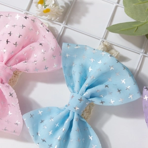 Détail de bandeaux pour bébé en dentelle avec motifs étoiles argentées et nœuds doux