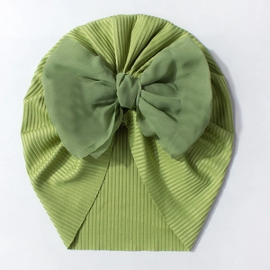 Vue détaillée du bonnet bébé vert avec tissu côtelé doux et grand nœud en mousseline