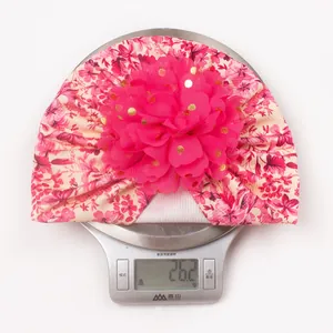 Détail du bonnet turban pour bébé à fleurs roses pesant 26,2g sur une balance