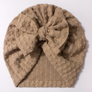 Detail shot of baby turban hat with oversized bow and 3D textured waffle fabric in khaki