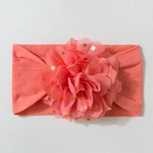 Détail du bandeau bébé rose corail avec pétales de fleurs en maille à pois dorés