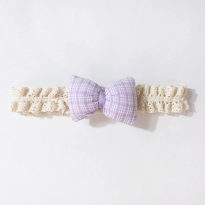 Detailaufnahme von Baby-Spitzenstirnband mit fliederfarbener Gingham-Schleife