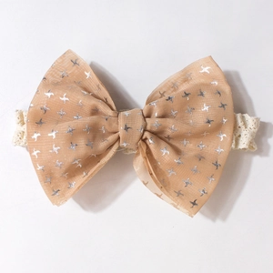 Détail du bandeau en dentelle pour bébé avec un grand nœud en mousseline et étoiles argent