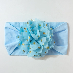 Détail du bandeau bleu clair pour bébé avec grande fleur en tulle à pois dorés