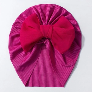 Détail du bonnet turban pour bébé avec grand nœud en mousseline rouge et maille côtelée