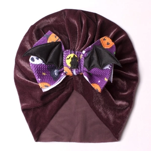 Détail du turban Halloween en velours violet avec nœud citrouille et ailes de chauve-souris