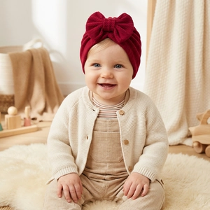 Detailed texture of dark red ribbed baby turban hat with large decorative bow on front