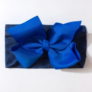 Close-up of baby headband with large blue ribbed bow and elastic knit fabric band