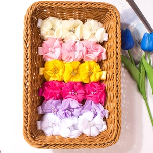 Dettaglio di fasce per capelli con fiori di chiffon colorati con perle e strass