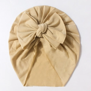 Detail of baby turban hat in khaki ribbed fabric featuring a large decorative bow tie
