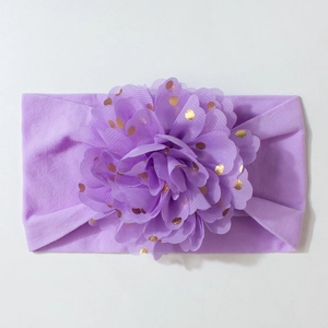 Détail d'un bandeau violet pour bébé avec une grande fleur en tulle et pois dorés brillants