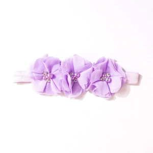 Dettaglio di fiori in chiffon viola con perle e cristalli su fascia morbida bimbi