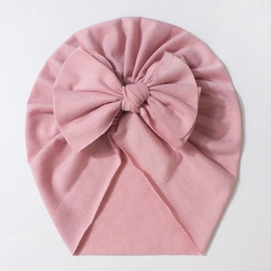 Pink rib-knit baby turban hat with a large bow decoration for infants and toddlers