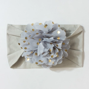 Détail d'un bandeau bébé avec bande grise et fleur à pois dorés pour décoration