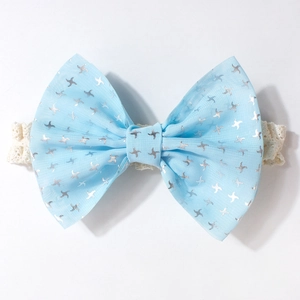Gros plan d'un bandeau bébé en maille bleu clair avec motifs étoiles et dentelle blanche