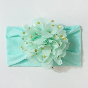 Détail du bandeau bébé vert menthe avec grande fleur en tulle et pois dorés