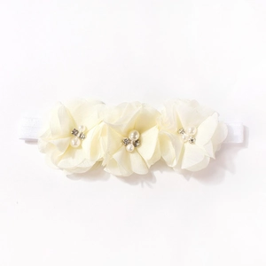 Dettaglio fascia per neonati con fiori di chiffon avorio, perle e strass lucenti