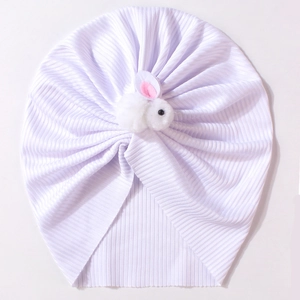Détail d'un bonnet turban blanc pour bébé en tricot avec un joli lapin en peluche