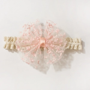 Close-up of baby lace headband with pink embroidered mesh bow on white background