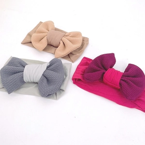 Three-piece set of soft elastic baby headbands with large textured bows in pink and blue